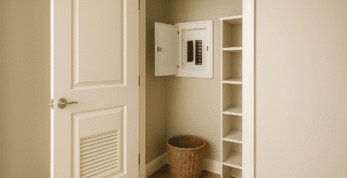 Clóset abierto con tablero eléctrico empotrado en la pared, tapa abierta, estantes vacíos y canasto; acceso libre y ventilación básica.