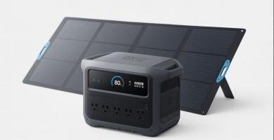 Estación de energía portátil Anker SOLIX C1000 Gen 2 con panel solar plegable detrás, pantalla encendida y tomas de CA frontales.
