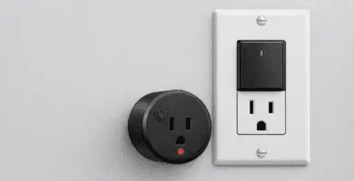 Enchufe con interruptor compacto con luz LED y toma de pared con interruptor; corte local para reducir consumo en standby.