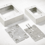 Cajas superficiales 2-gang y 1-gang con placa base metálica y tornillos, listas para montaje sobre muro con canaleta