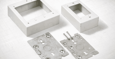 Cajas superficiales 2-gang y 1-gang con placa base metálica y tornillos, listas para montaje sobre muro con canaleta