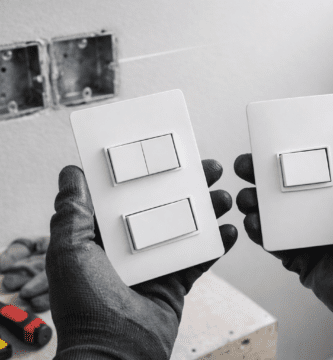 Técnico sostiene interruptores simple y doble formato 2×4; suministro e instalación de interruptores en Santiago.